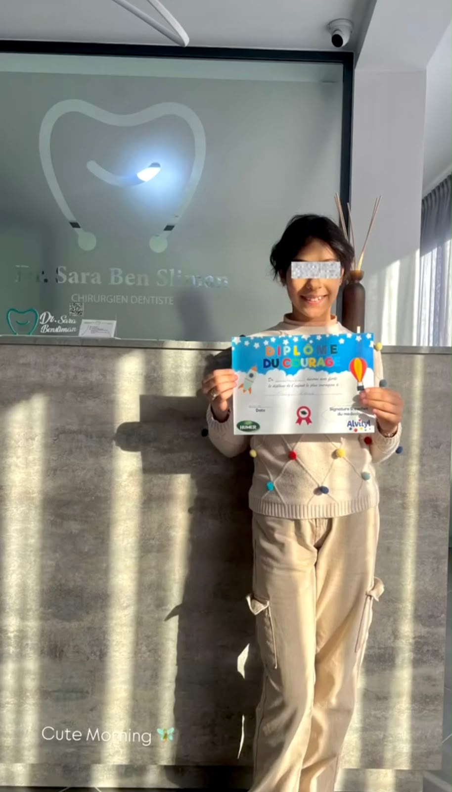 Jeune patiente fière de son diplôme de super héros dentaire
